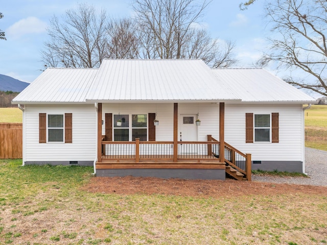 ranch-style home with crawl space, covered porch, a front lawn, and metal roof