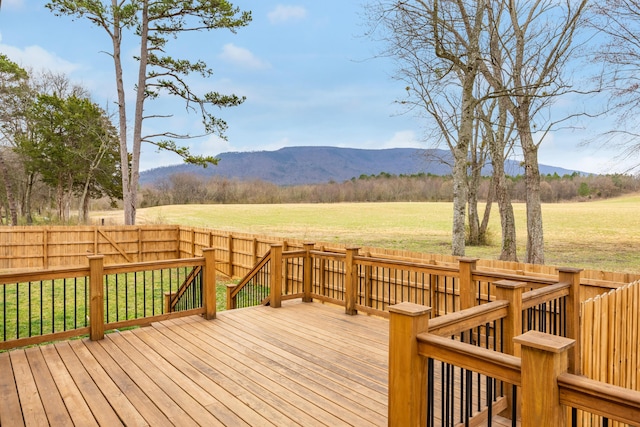 wooden deck with fence, a mountain view, a lawn, and a rural view