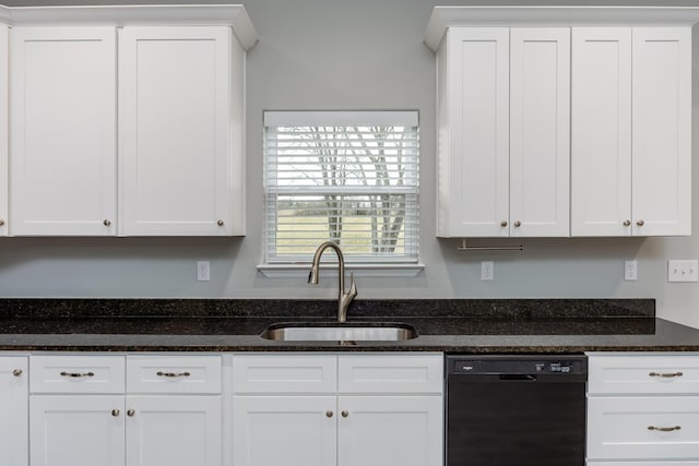 kitchen featuring black dishwasher, white cabinets, a sink, and dark stone countertops