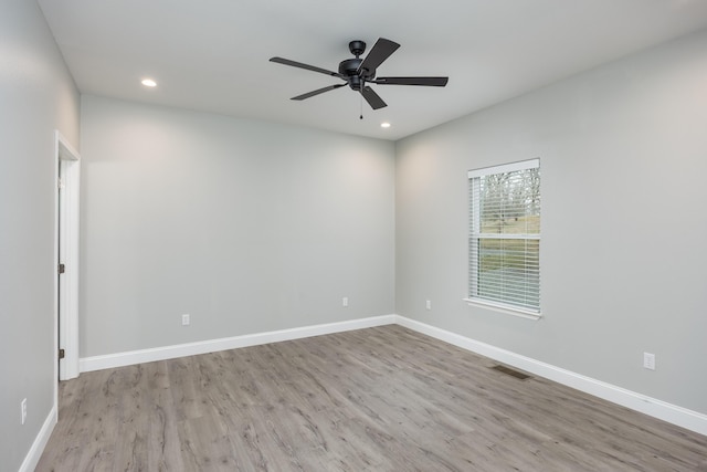 unfurnished room with recessed lighting, wood finished floors, visible vents, and baseboards