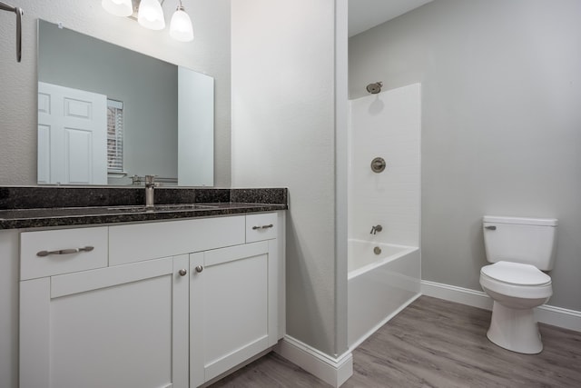 bathroom featuring baseboards, vanity, toilet, and wood finished floors