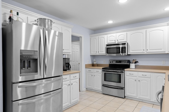 kitchen with white cabinetry, stainless steel appliances, light countertops, and light tile patterned flooring