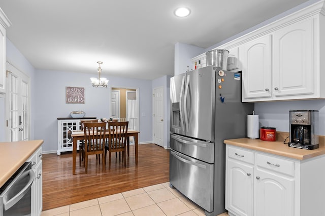 kitchen featuring white cabinetry, stainless steel appliances, light countertops, and light tile patterned flooring