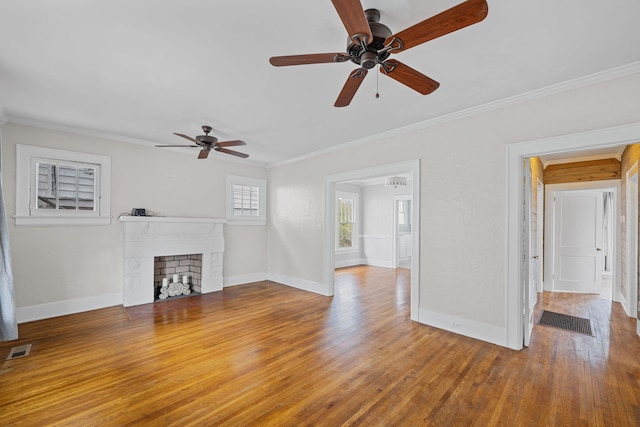 unfurnished living room featuring a fireplace with flush hearth, visible vents, crown molding, and wood finished floors