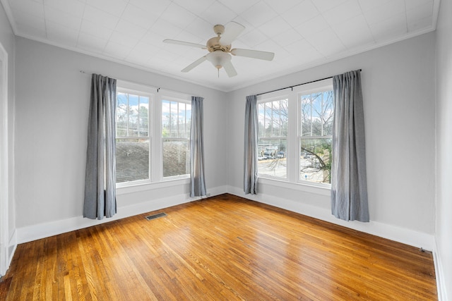 unfurnished room featuring visible vents, crown molding, light wood-style flooring, and baseboards