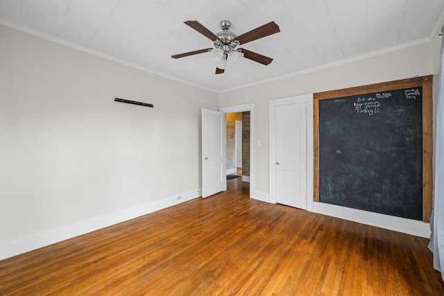 unfurnished bedroom with crown molding, wood finished floors, and baseboards