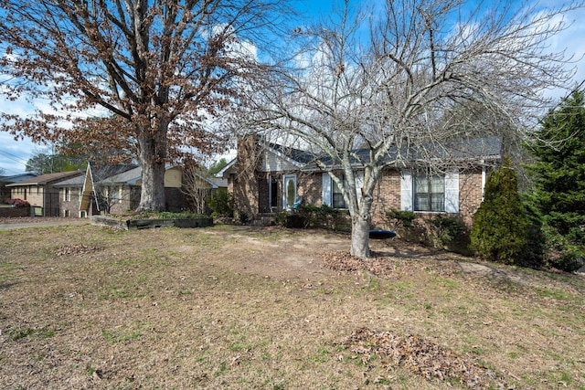 view of front of home featuring a front yard and brick siding