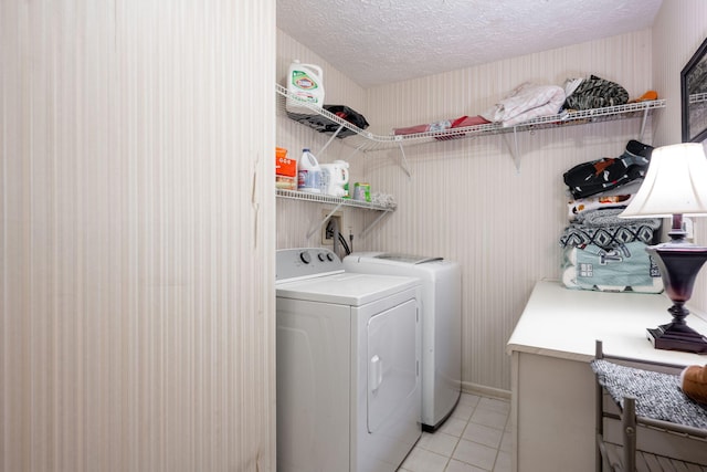 washroom featuring a textured ceiling, laundry area, light tile patterned floors, and independent washer and dryer