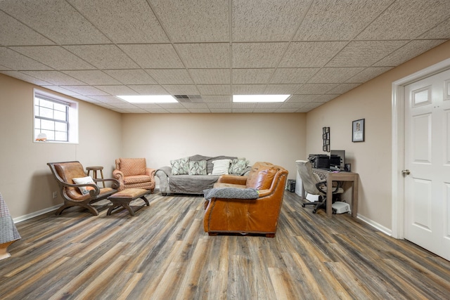 living area featuring baseboards, visible vents, a drop ceiling, and wood finished floors