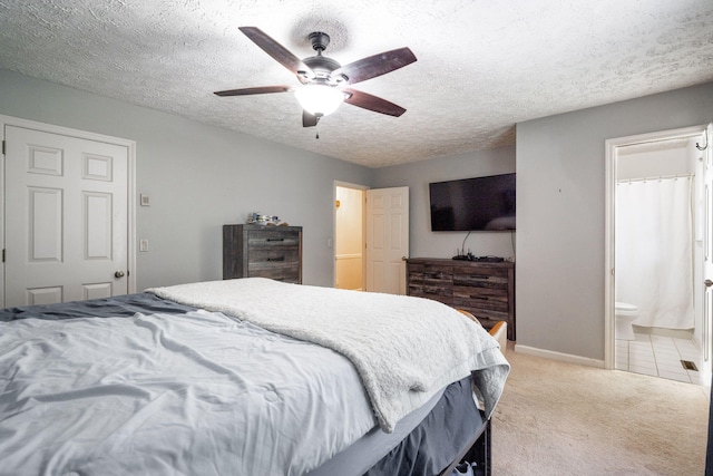 bedroom with light carpet, baseboards, a ceiling fan, connected bathroom, and a textured ceiling