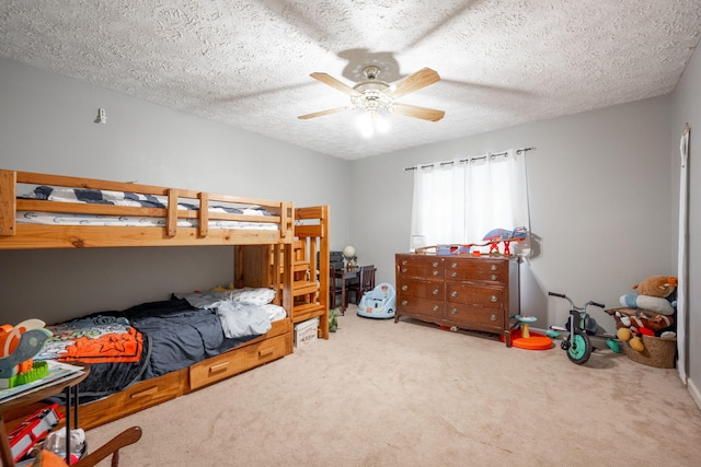 bedroom with a textured ceiling, ceiling fan, and carpet