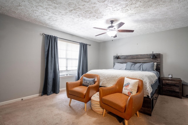 bedroom featuring a ceiling fan, light colored carpet, a textured ceiling, and baseboards