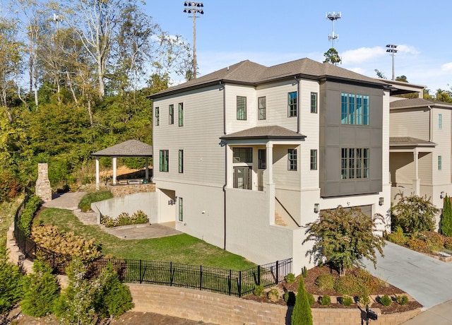 exterior space featuring fence, a gazebo, a yard, driveway, and a patio