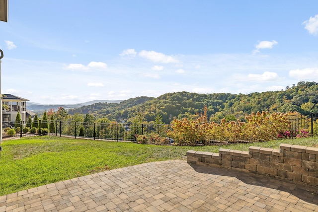 exterior space with a mountain view, a view of trees, and fence