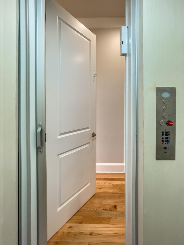 hall with baseboards and light wood-type flooring