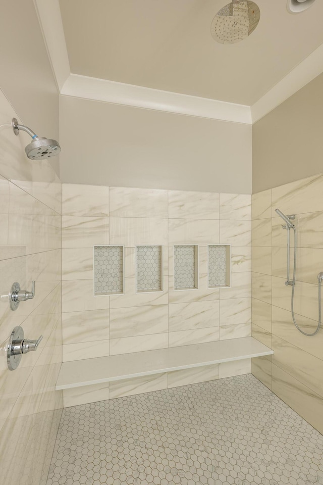 bathroom with crown molding and tiled shower