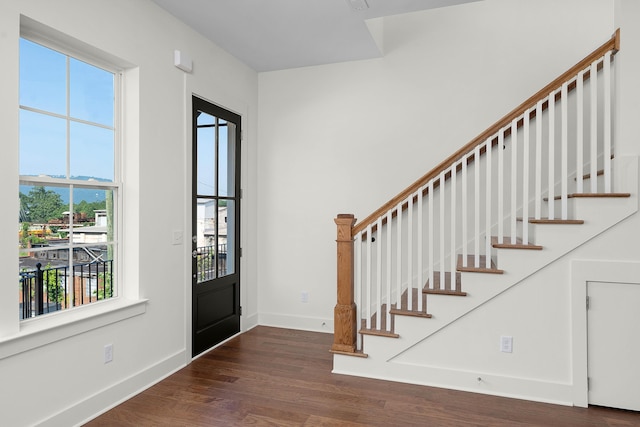 foyer with stairway, baseboards, and wood finished floors