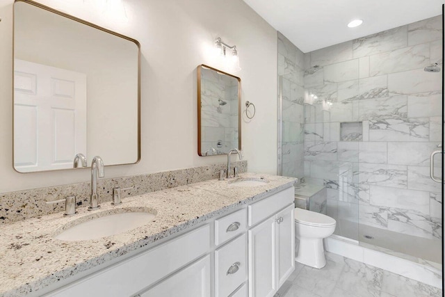 bathroom featuring marble finish floor, a sink, toilet, and a shower stall