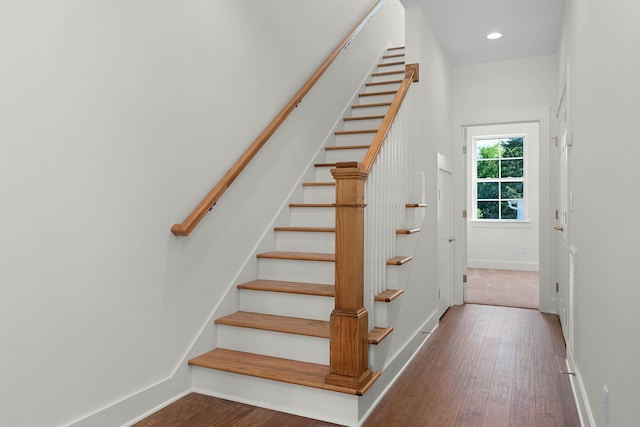 staircase with recessed lighting, wood-type flooring, and baseboards