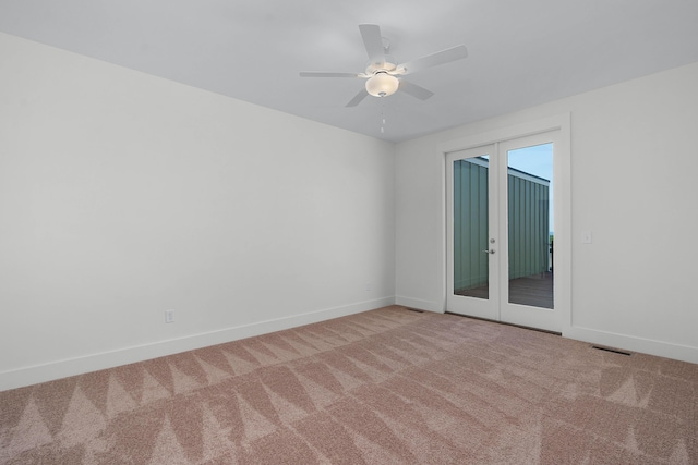 carpeted empty room featuring french doors, visible vents, ceiling fan, and baseboards