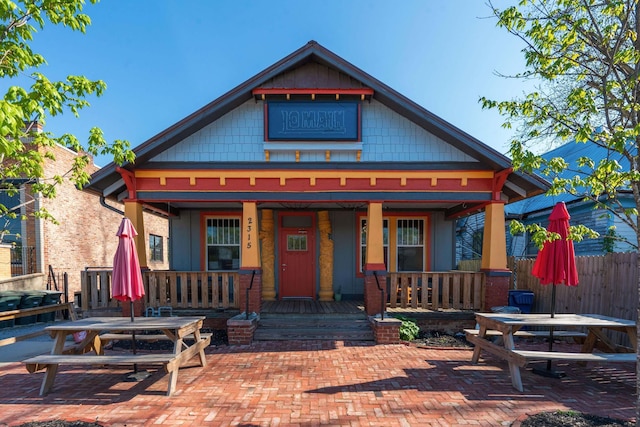 view of front of home featuring a porch and fence