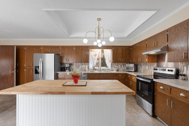 kitchen featuring stainless steel appliances, a raised ceiling, a sink, and under cabinet range hood