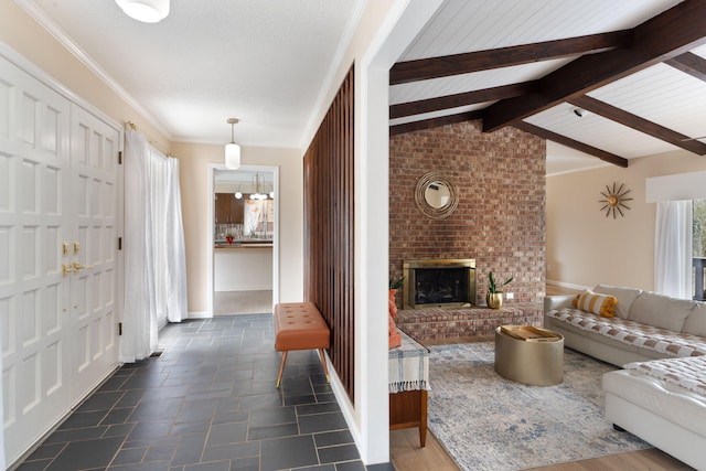 living room with vaulted ceiling with beams, a brick fireplace, stone tile floors, and baseboards