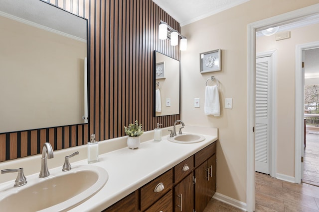 full bathroom with double vanity, a sink, and crown molding