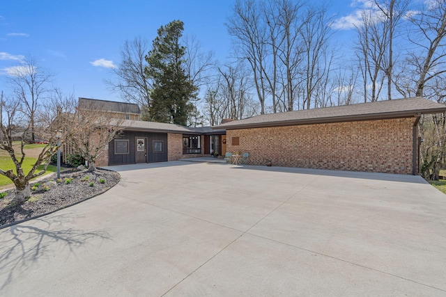 view of front of home with driveway and brick siding