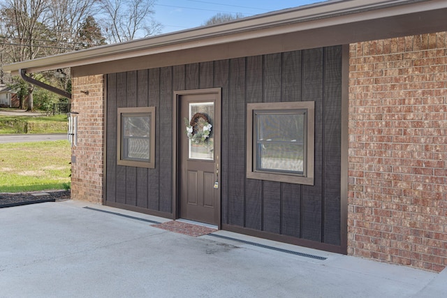 doorway to property featuring brick siding