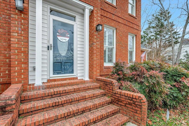 view of exterior entry with brick siding