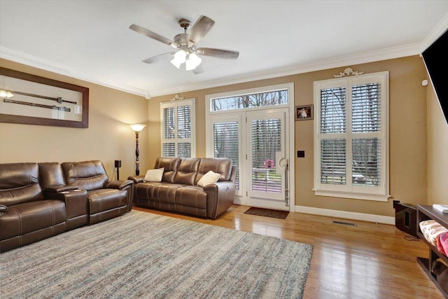 living room with visible vents, crown molding, baseboards, and wood finished floors