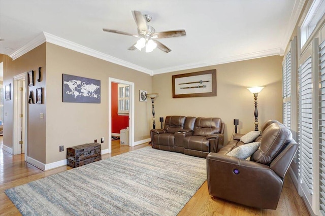 living room featuring baseboards, ornamental molding, ceiling fan, and wood finished floors