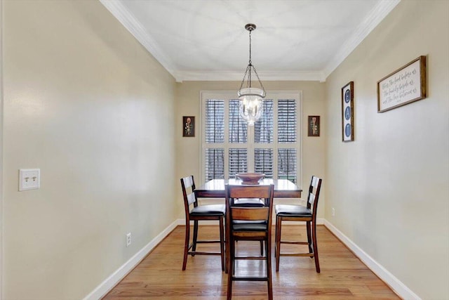 dining area with crown molding, baseboards, a notable chandelier, and light wood-style floors