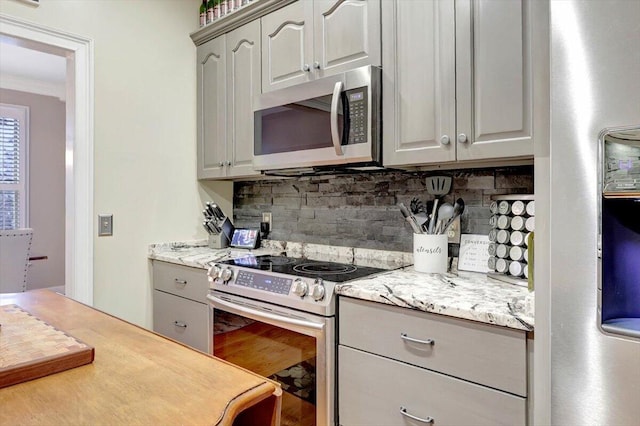 kitchen with tasteful backsplash, appliances with stainless steel finishes, and gray cabinets