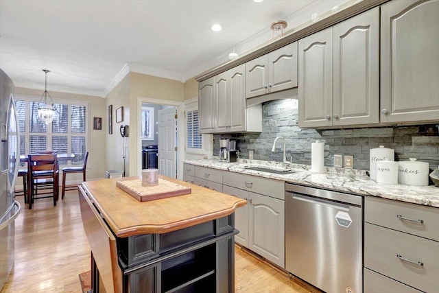 kitchen featuring decorative backsplash, light wood-style flooring, ornamental molding, stainless steel dishwasher, and a sink