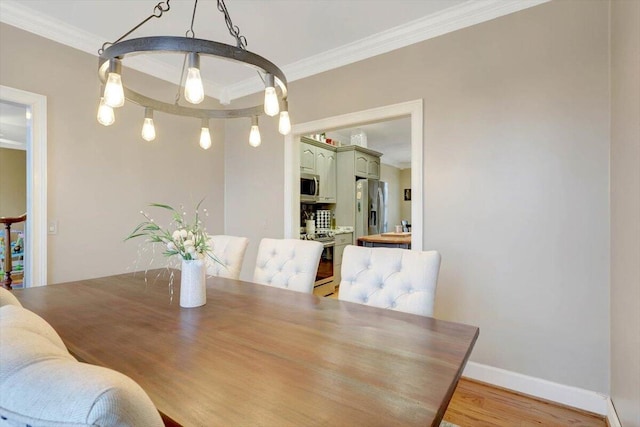 dining space with baseboards, light wood finished floors, and crown molding