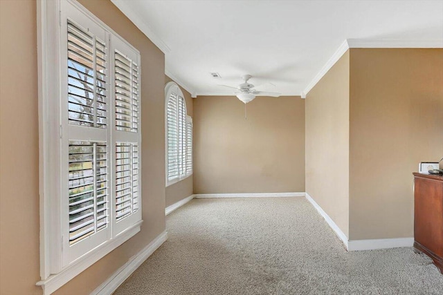 empty room with ceiling fan, carpet floors, visible vents, baseboards, and ornamental molding