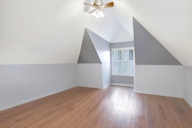 bonus room with lofted ceiling, baseboards, a ceiling fan, and wood finished floors