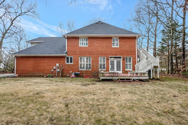 back of house with a yard, a shingled roof, and brick siding