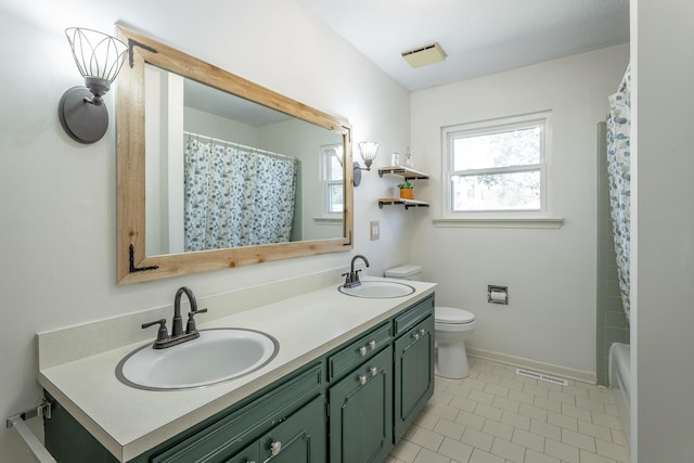 bathroom with a sink, visible vents, toilet, and double vanity