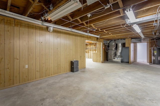 unfinished below grade area with heating unit, wood walls, and water heater