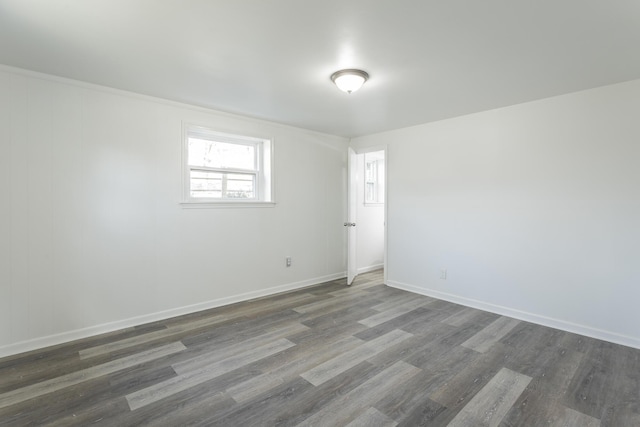 unfurnished room with dark wood finished floors and baseboards