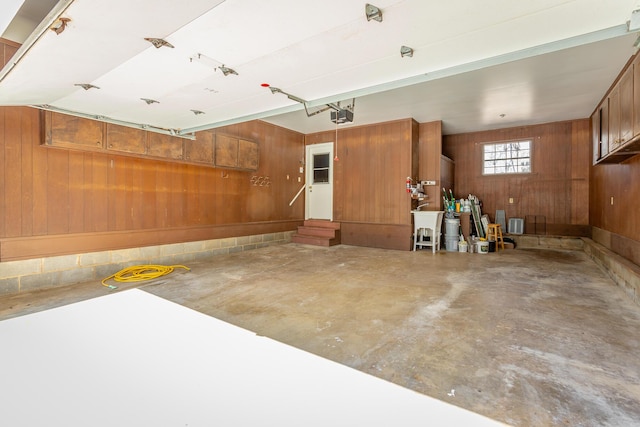 garage with a garage door opener and wood walls