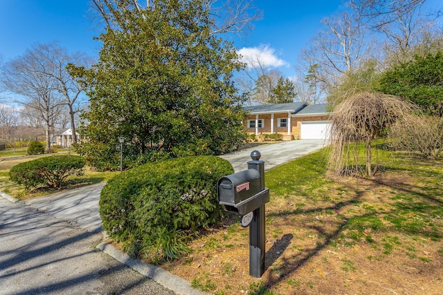 view of front of home with brick siding, driveway, and a garage