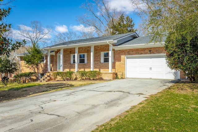 ranch-style house featuring driveway, a porch, roof with shingles, an attached garage, and brick siding