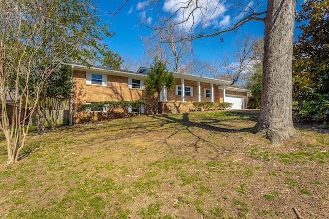 ranch-style home with a front yard, an attached garage, and brick siding