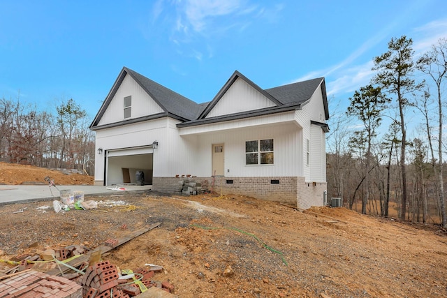 modern farmhouse style home featuring central air condition unit, a garage, driveway, roof with shingles, and crawl space