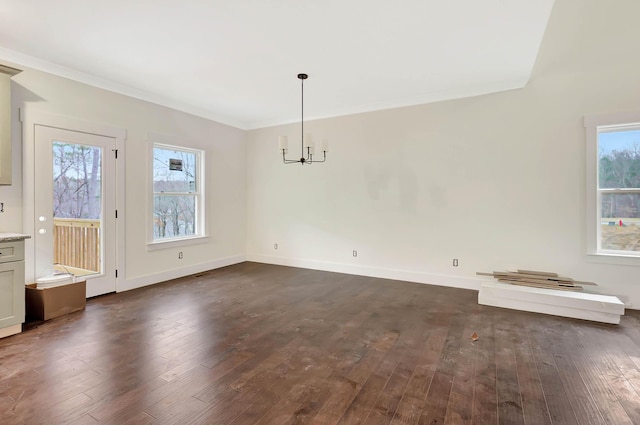 unfurnished dining area featuring a healthy amount of sunlight, dark wood finished floors, and crown molding