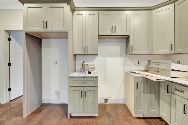 kitchen featuring dark wood-type flooring, baseboards, and light stone counters